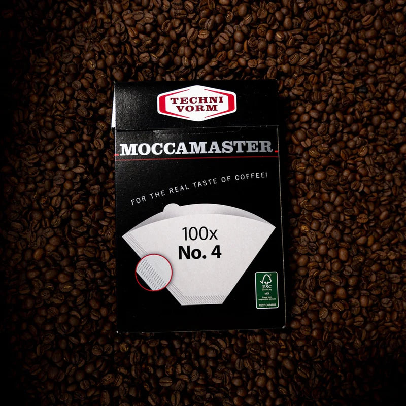 Filtros para café moka rodeados de granos de café.